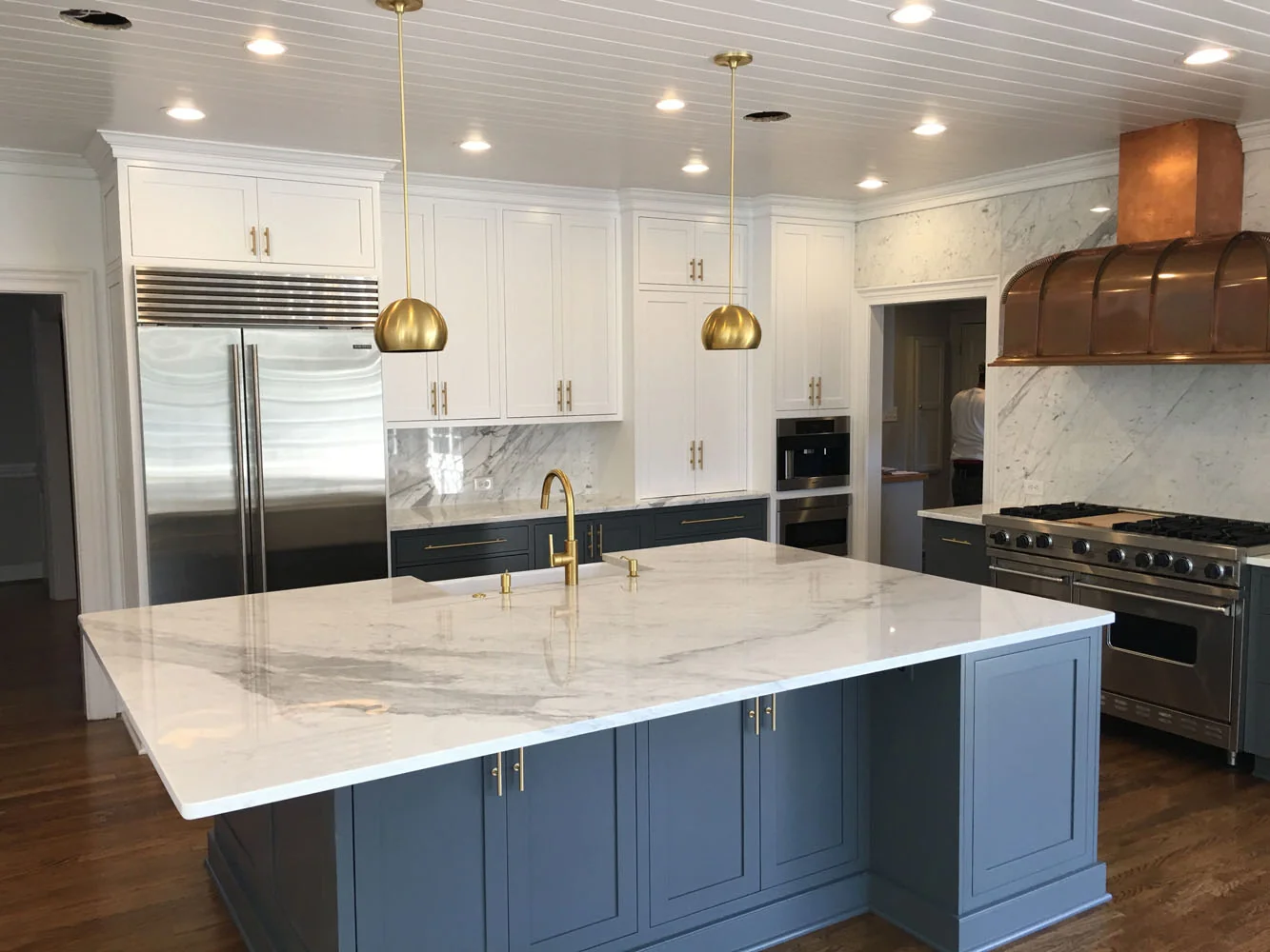Kitchen with painted blue island and marble counters