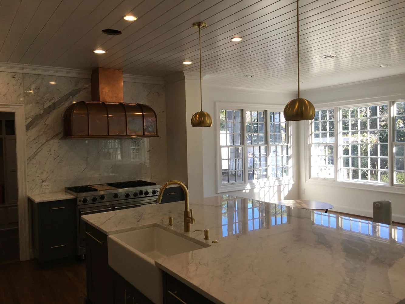 Kitchen with copper range hood and marble backsplash