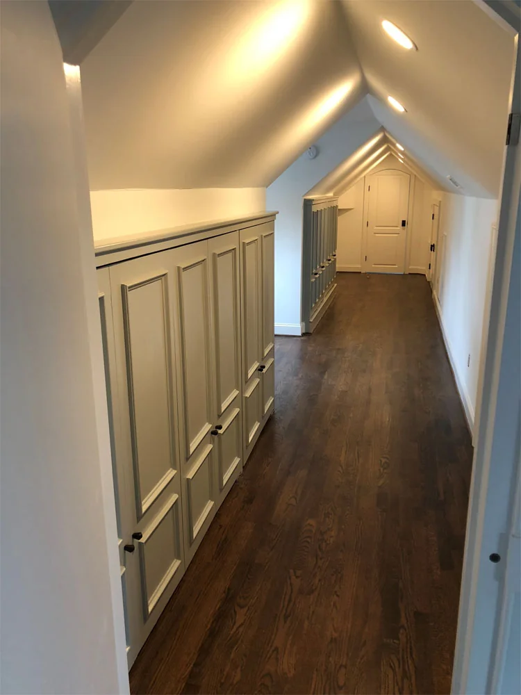 Attic hallway with painted built-in cabinets